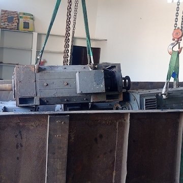 Large motor lifted on a chain hoist for repair